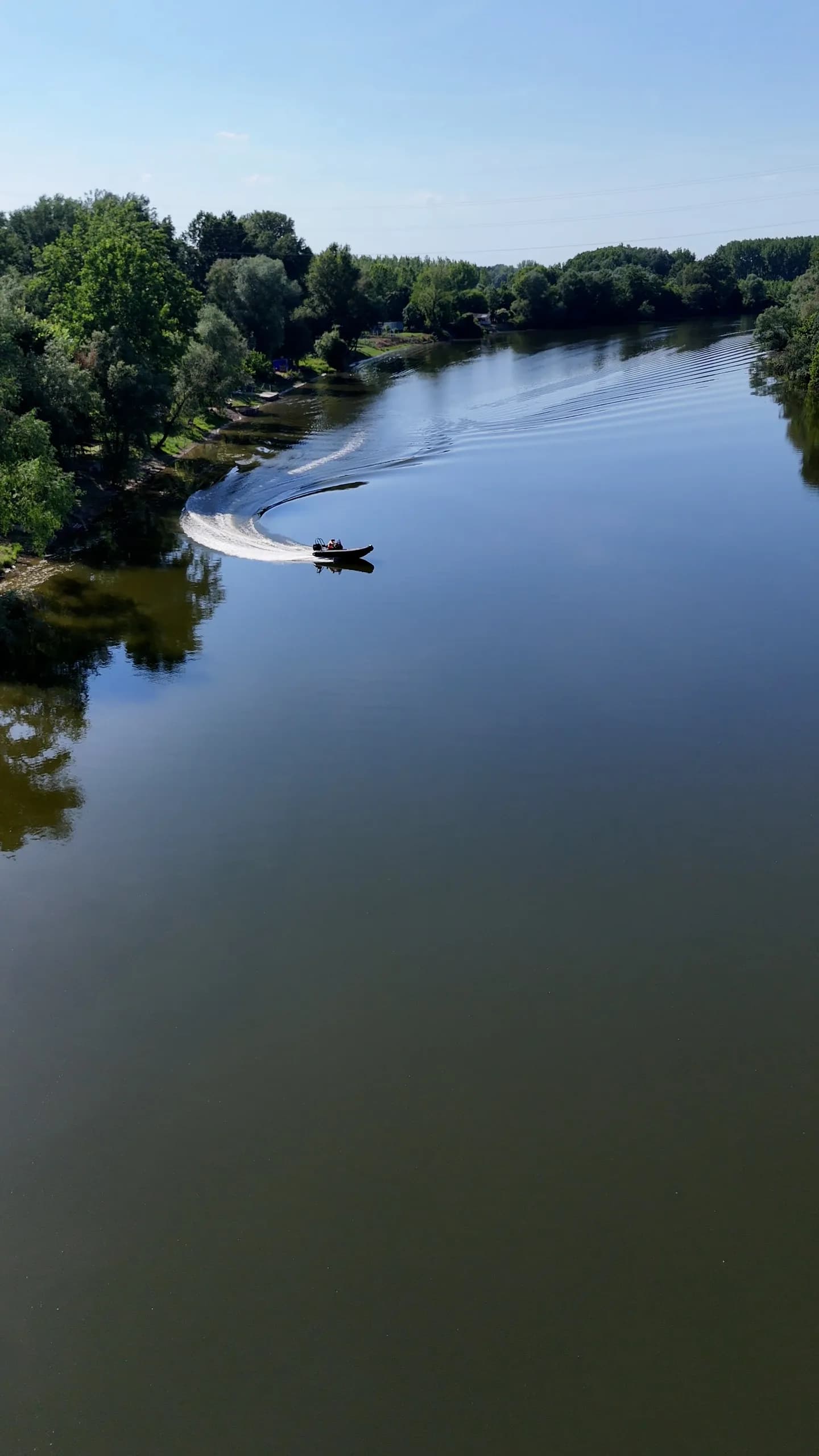 Čamac ostavlja trag na mirnoj površini Morave, snimak iz vazduha